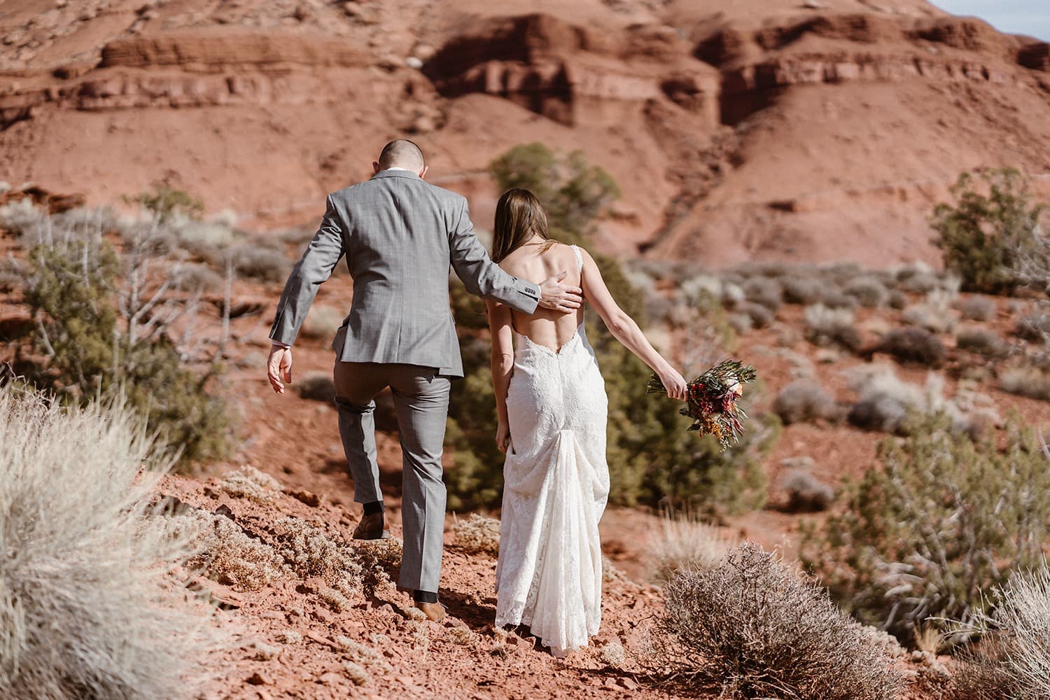 Bride and Groom Hiking During Moab Elopement