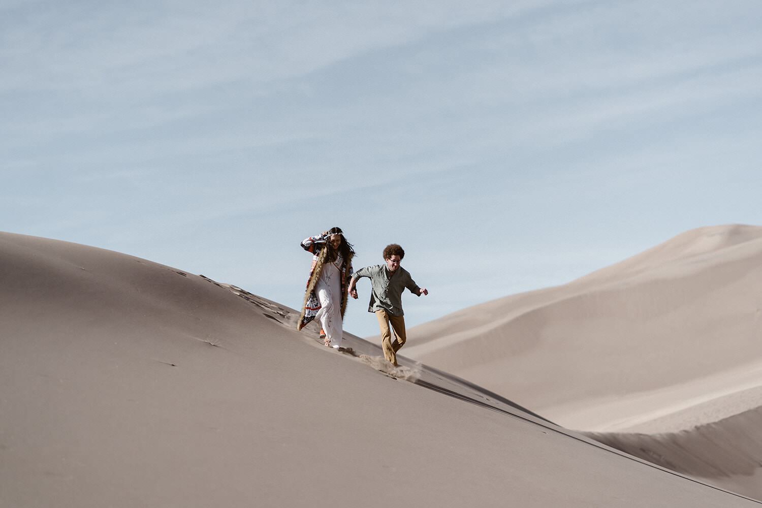 Bride and Groom running at Colorado Great Sand Dunes Elopement