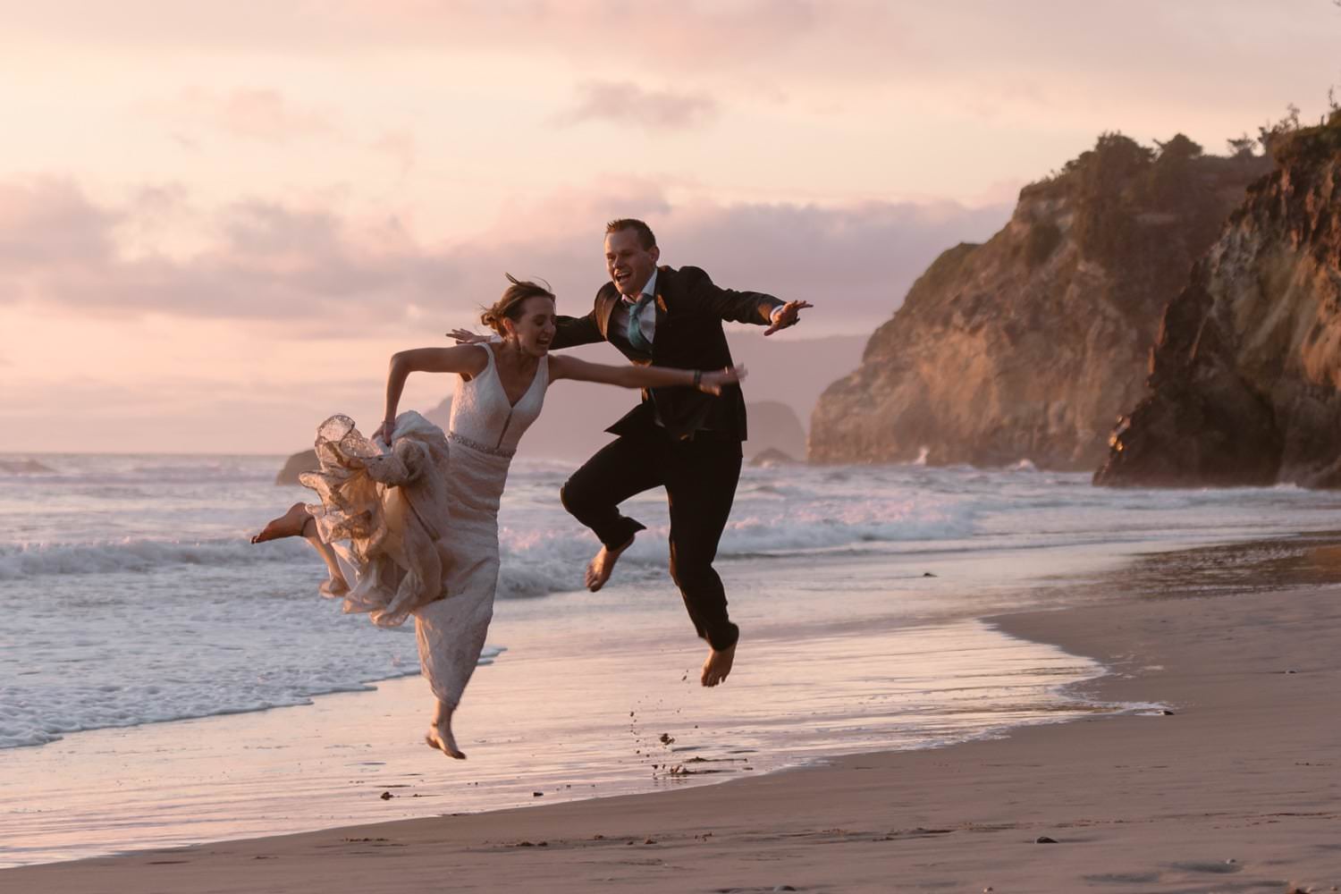 Bride and Groom jumping in the air at Hug Point & Cannon Beach Elopement