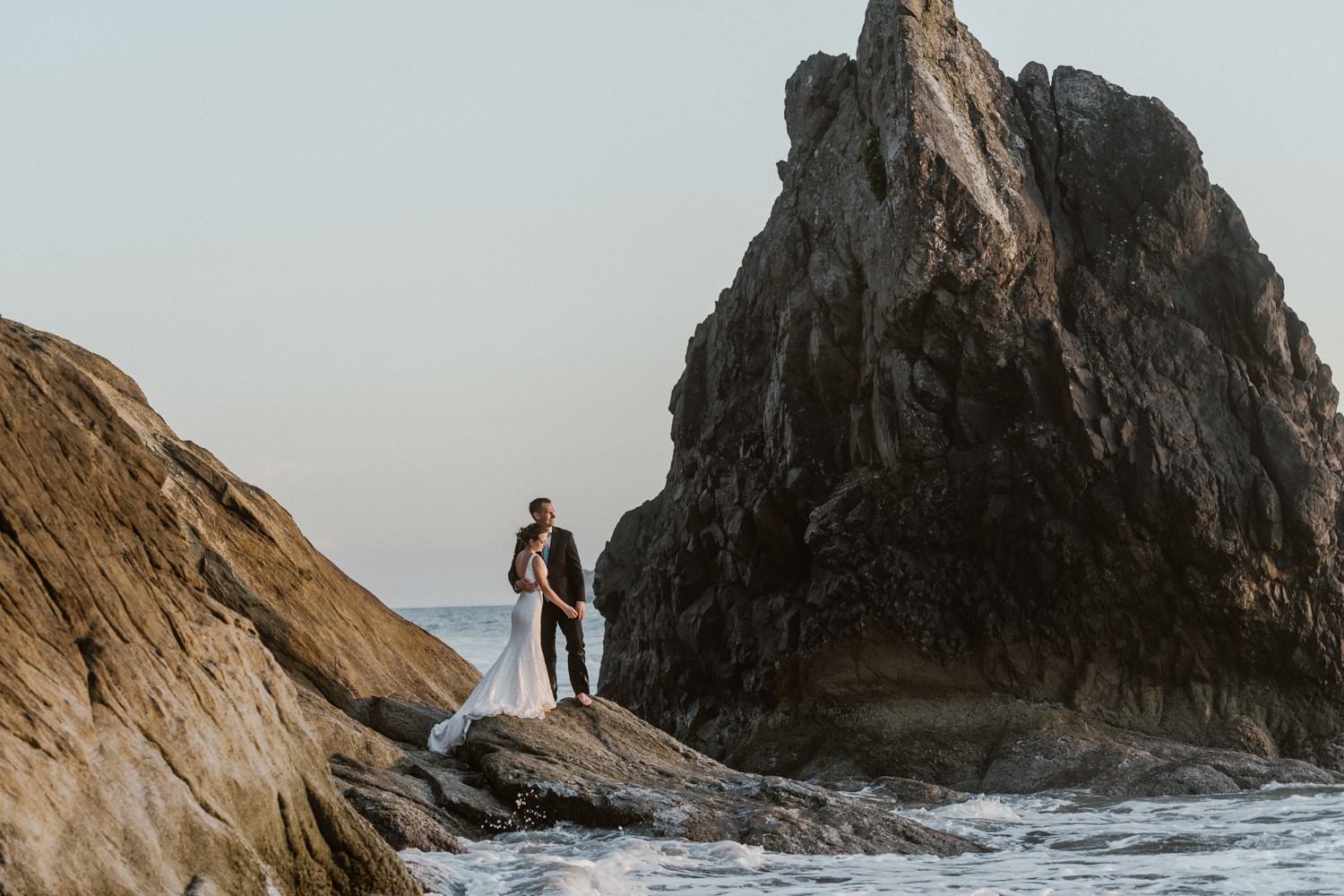 Bride and Groom posing on rock at Hug Point Elopement