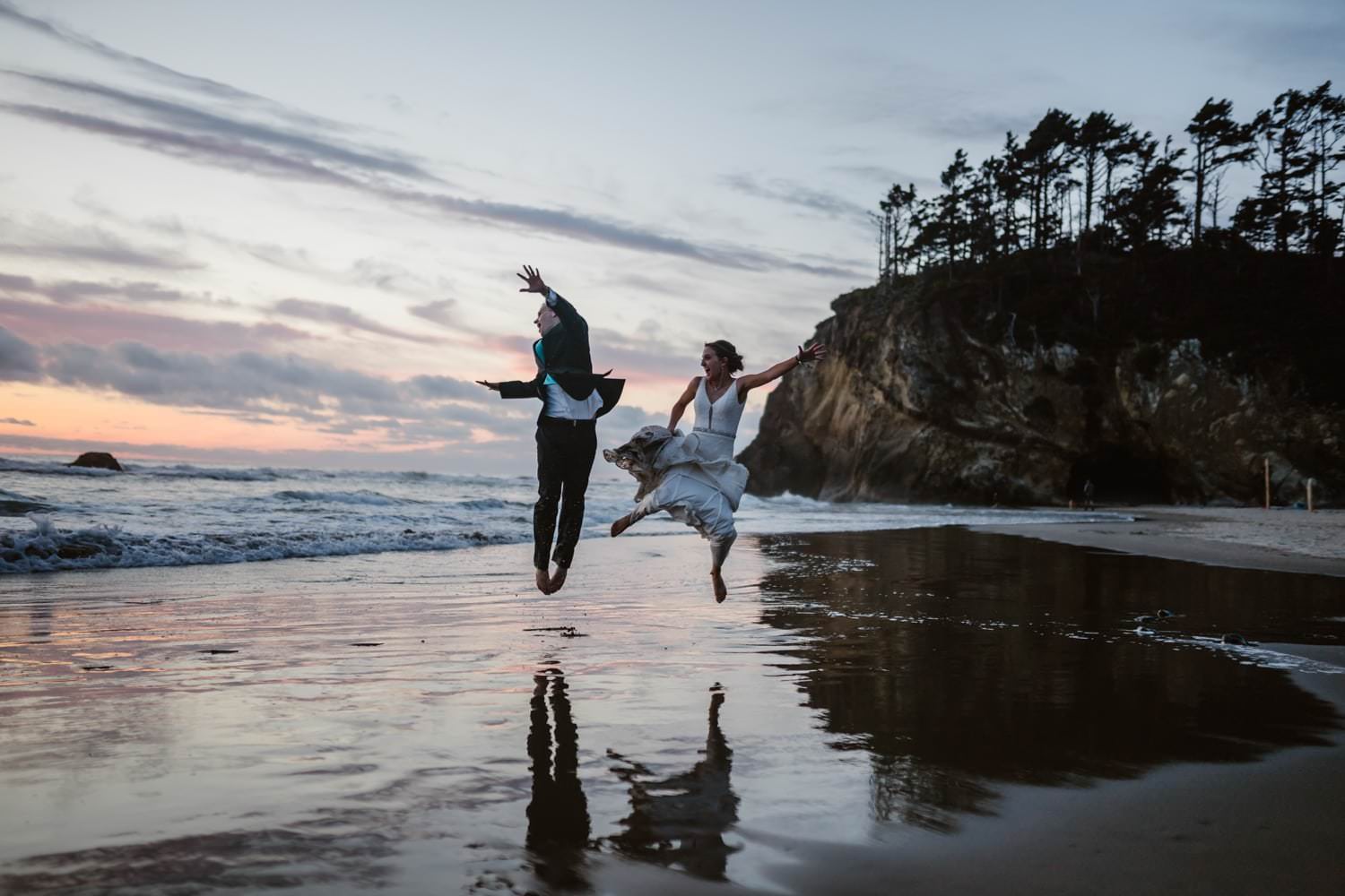 Bride and Groom jumping in the air at Hug Point & Cannon Beach Elopement