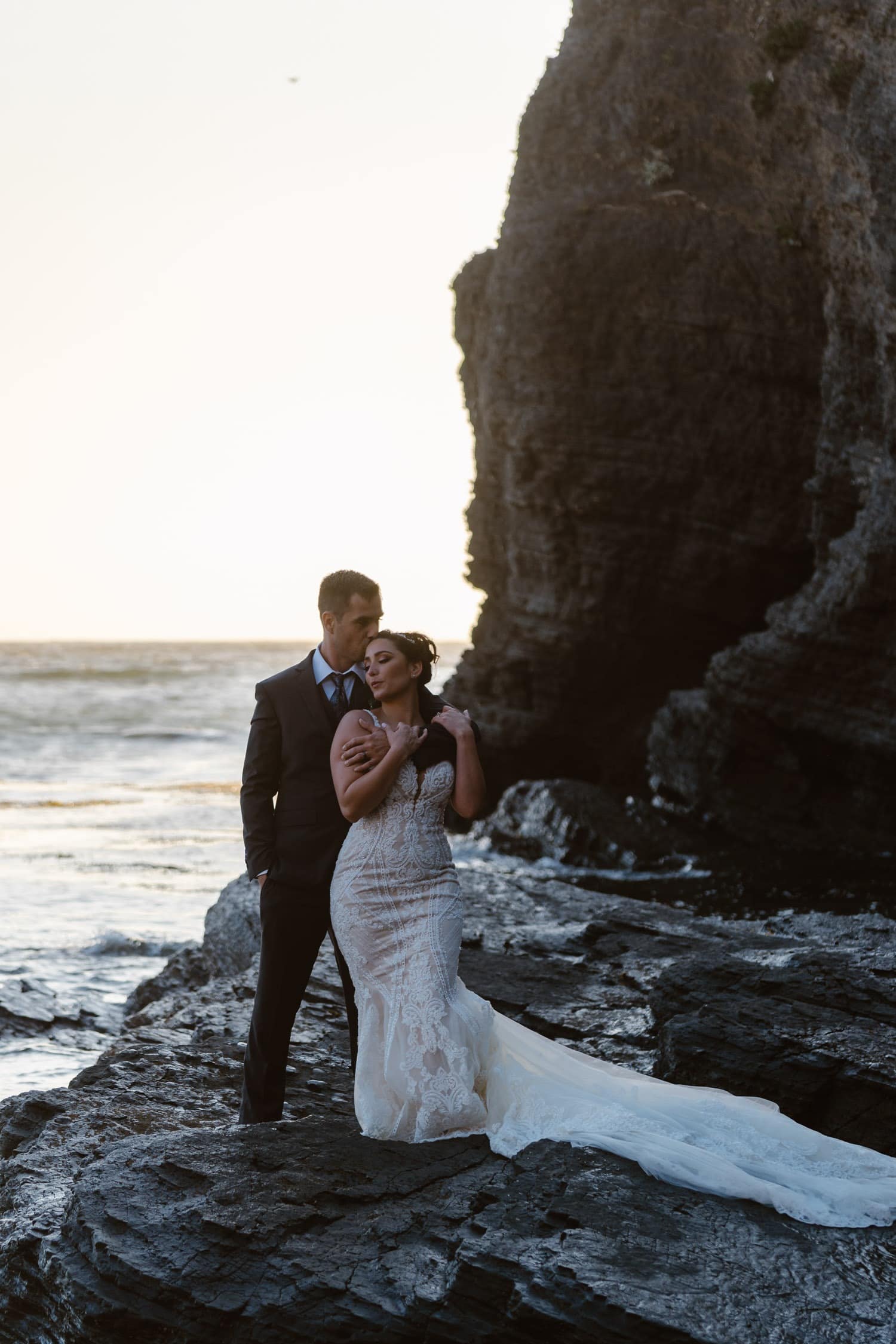 Groom kissing bride at sunset at Big Sur Elopement