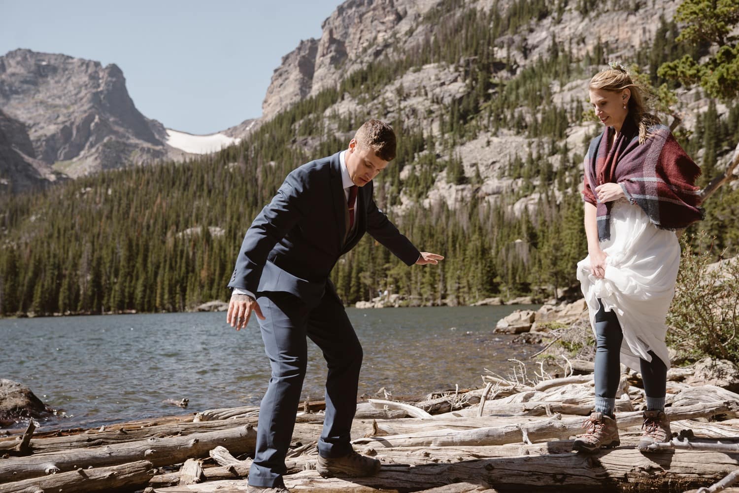 Bride and groom hiking at Loch Lake at Rocky Mountain National Park Hiking Elopement