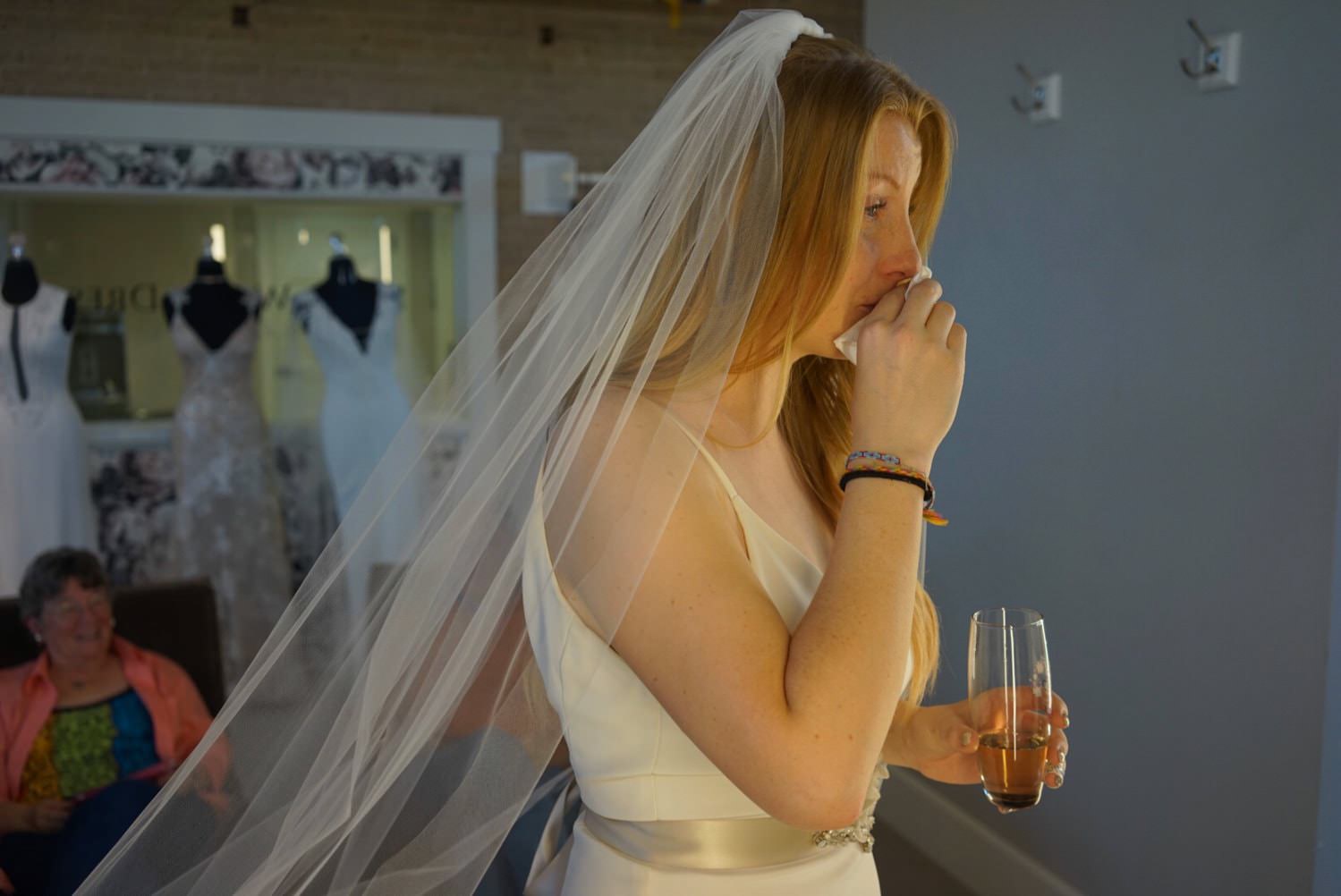 A bride getting emotional trying on wedding dresses.