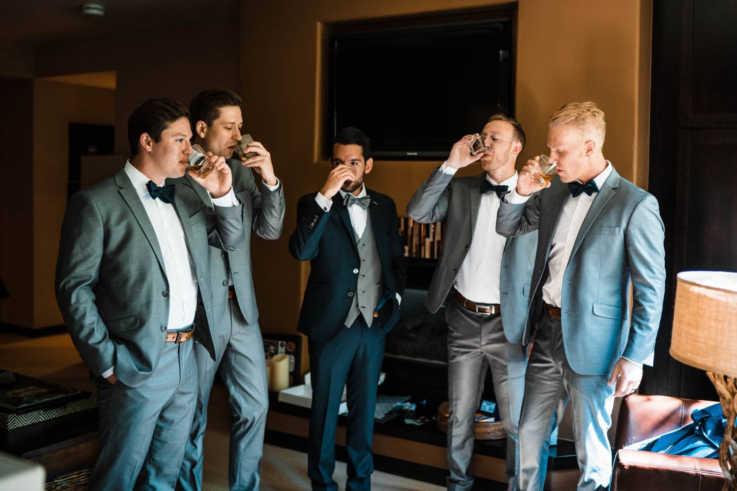 Groom getting ready with his friends at their Airbnb elopement.