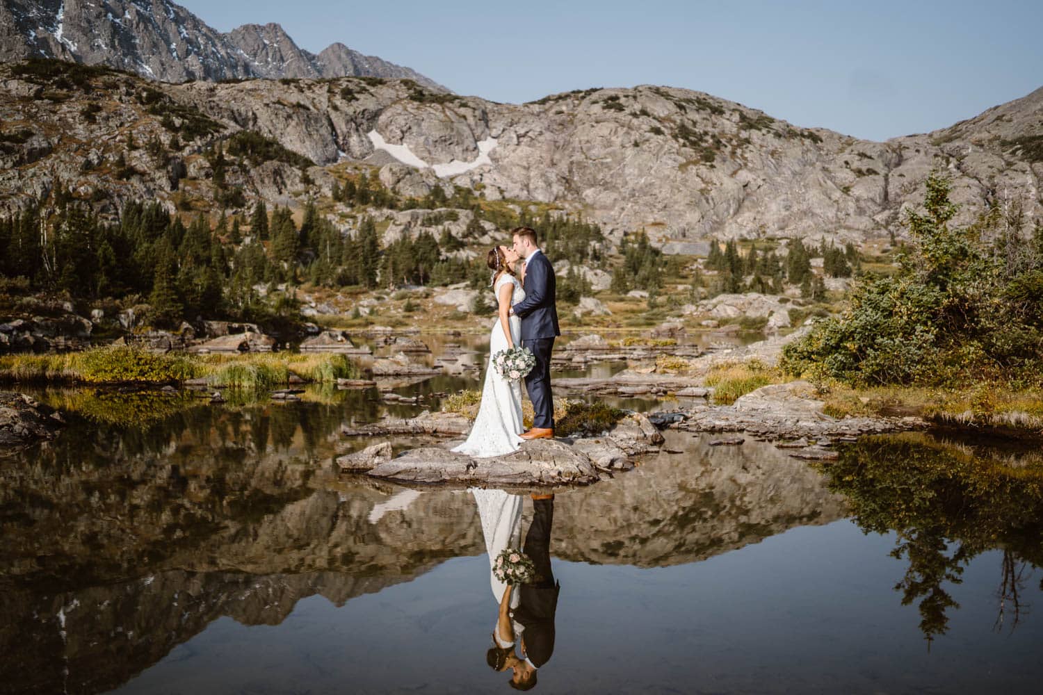 A couple in the reflection on an alpine lake in Colorado.