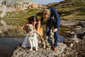 Couple hugging their dog next to a lake in Colorado during their elopement.