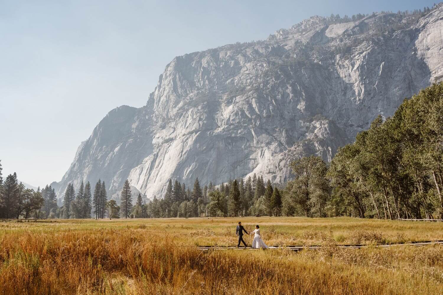 Couple walking across the bridge in Yosemite for their Yosemite.