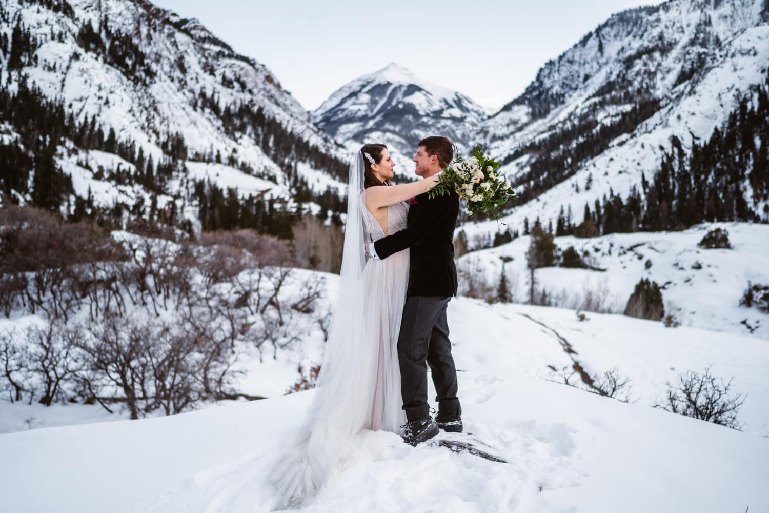 Bruid en Bruidegom knuffelen in de sneeuw Beste plaatsen om te elopen in Colorado