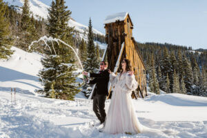 Couple spraying champagne after eloping in the mountains