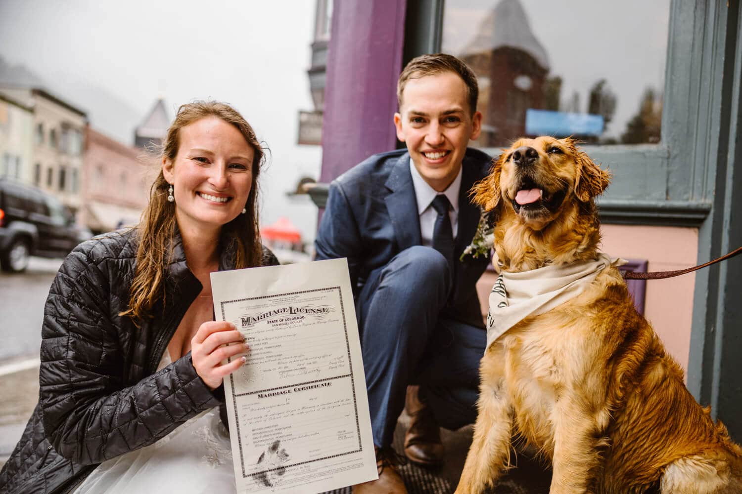 A couple and their dog signing their marriage license after their Self-Solemnization in Colorado.