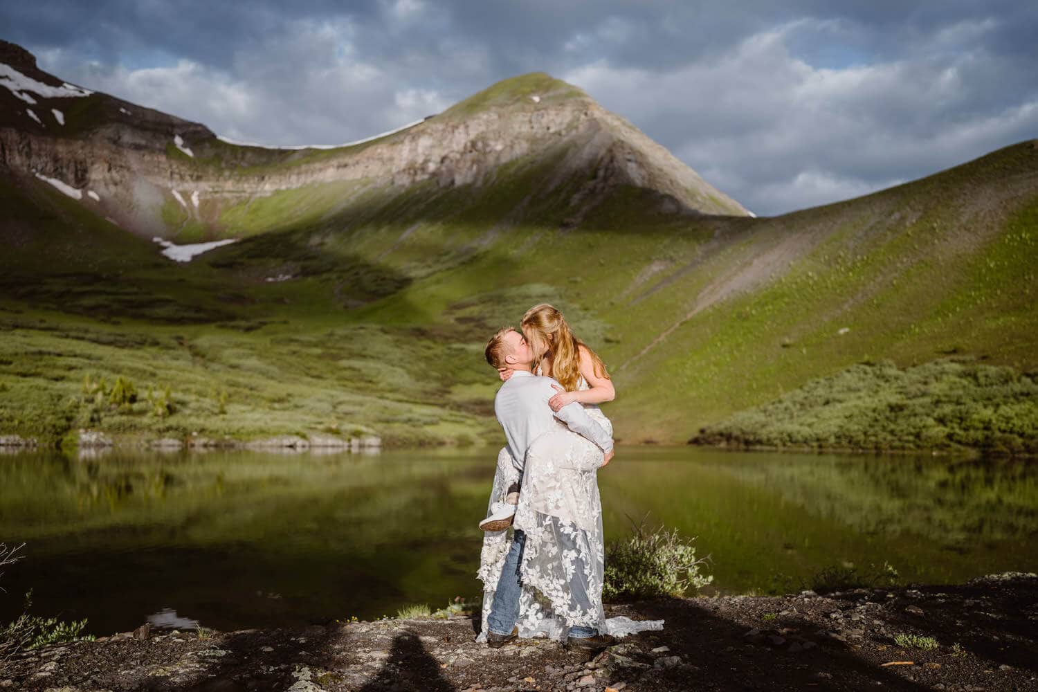 A couple sharing an intimate kiss at an alpine lake in Colorado.