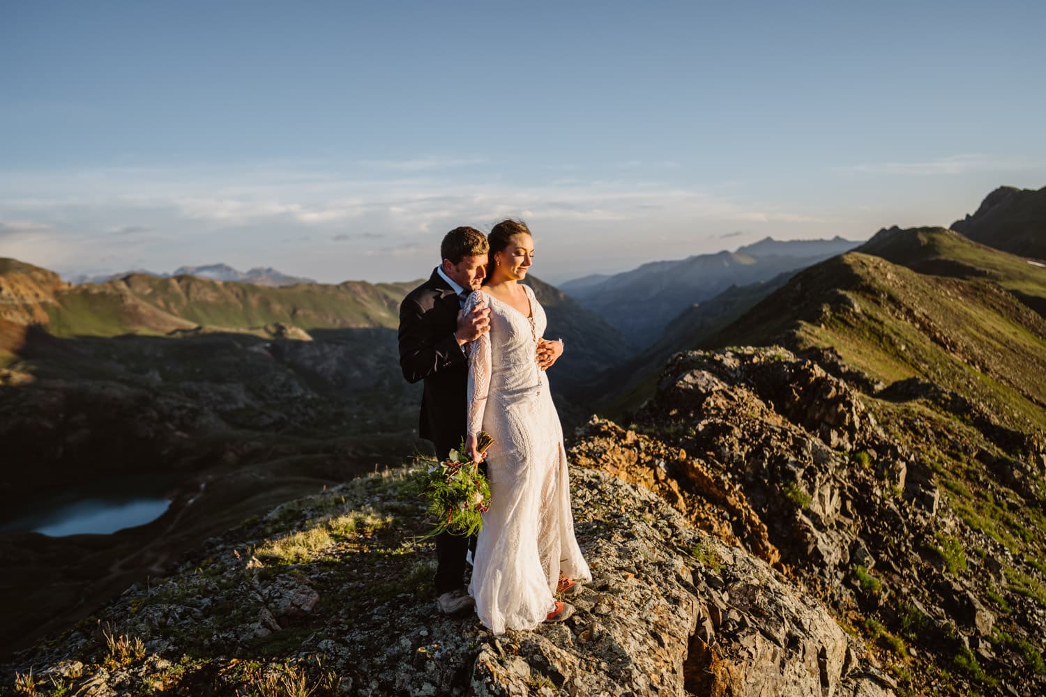 Bride and groom sharing an intimate moment in the mountains at sunrise.