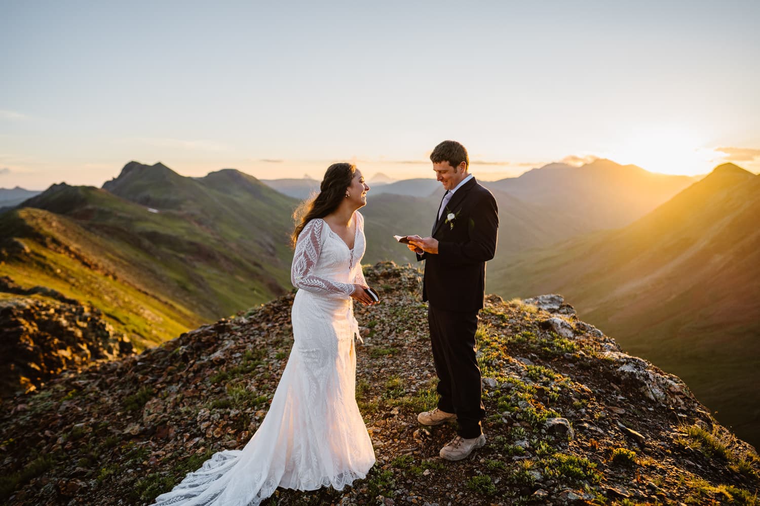 A bride laughing during her elopement ceremony at sunrise.