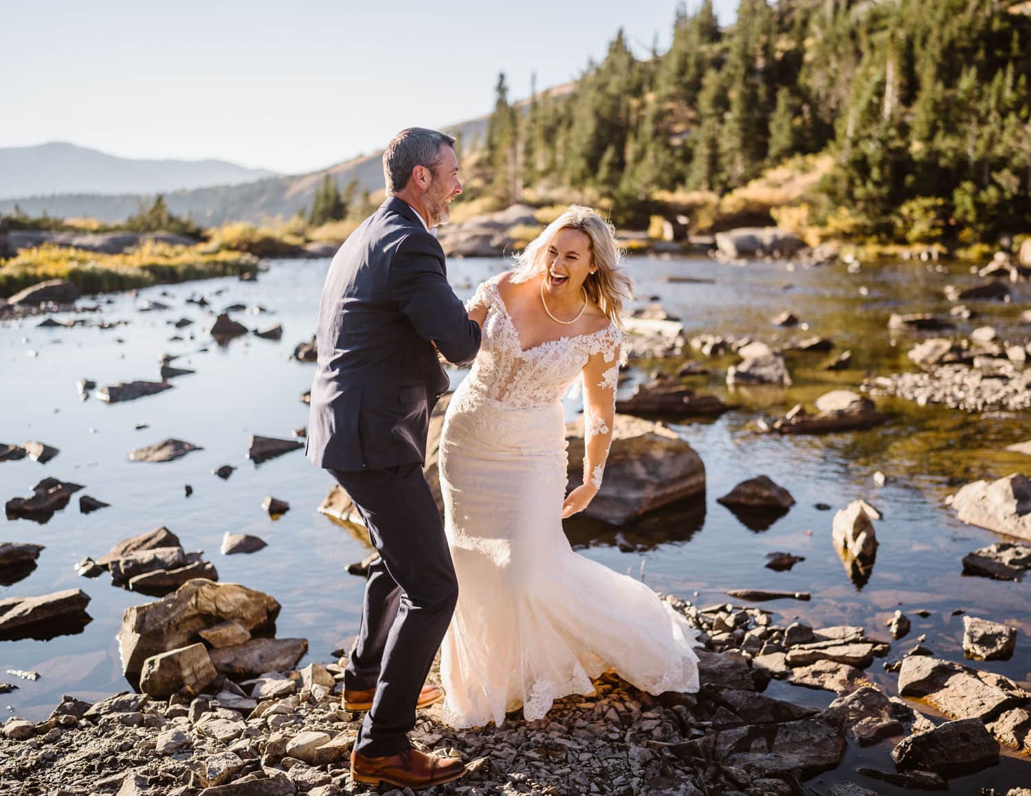 A couple sharing a laugh near an alpine lake at Breckenridge, Colorado for their elopement.