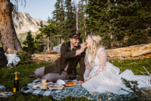 Couple sharing food at a picnic during their elopement in Colorado.