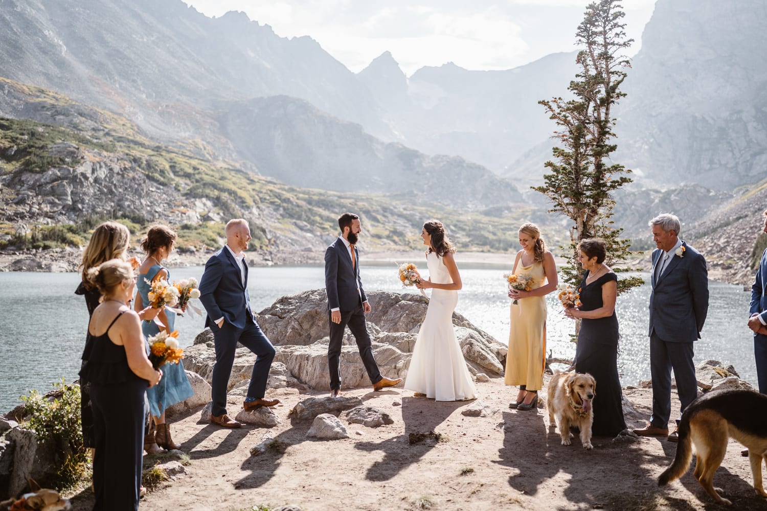 A couple getting married with their families at an alpine lake after their Self-Solemnization elopement