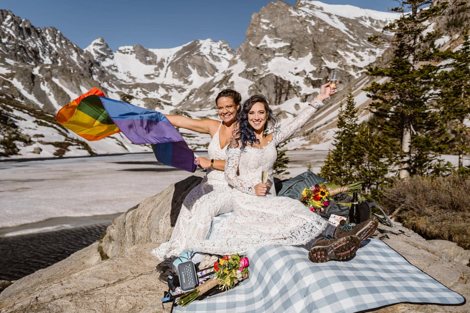 Two girls sharing a toast with their LGBTQ flag at their Colorado elopement.