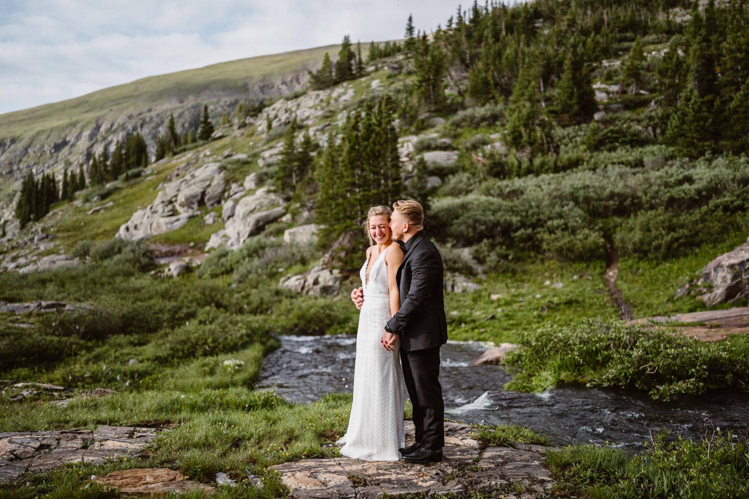 A couple sharing an intimate moment near a waterfall on their elopement day.