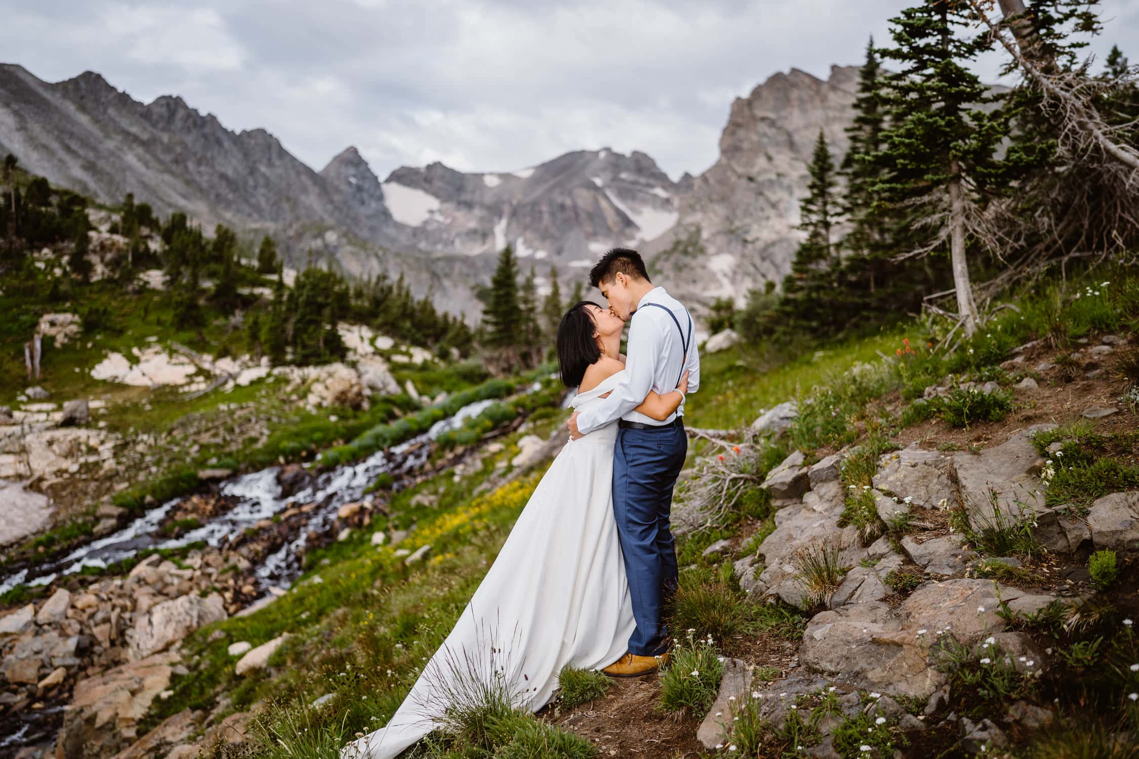 A couple sharing a kiss in the wildflowers of Colorado on their wedding day.