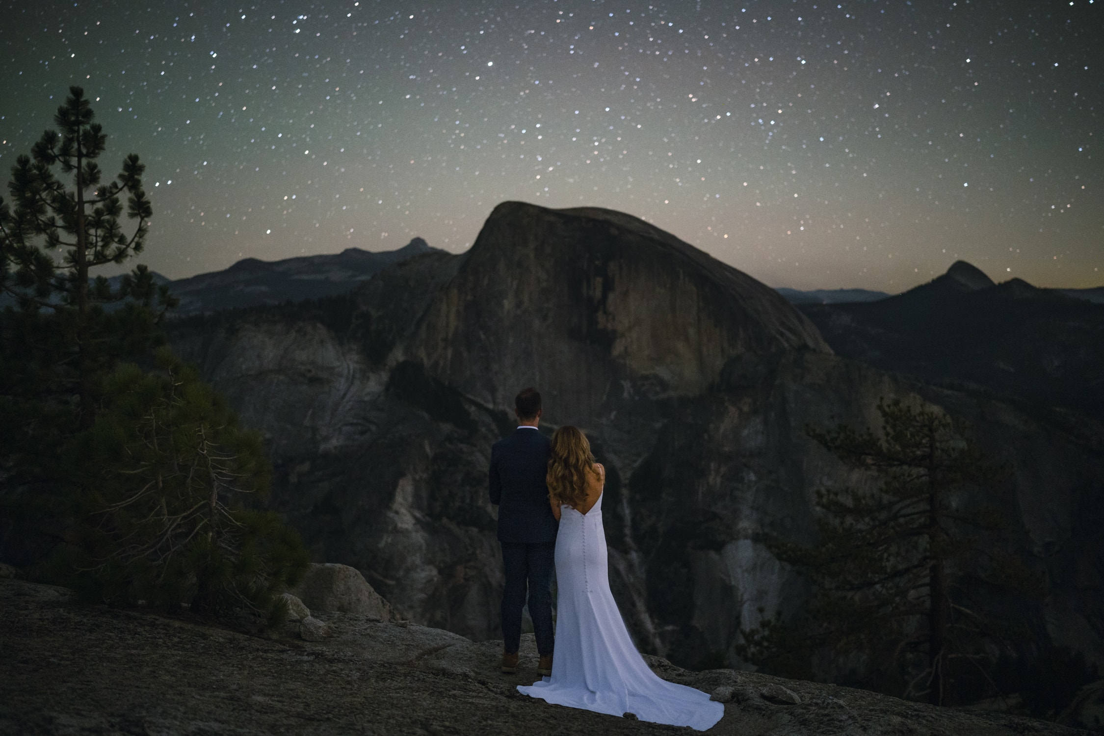 Bride and groom looking at Half Dome under the stars for their elopement in Yosemite.