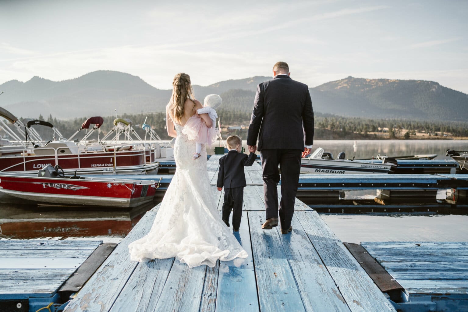 Bride and groom walking down a boat ramp with their kids on their wedding day in Colorado.