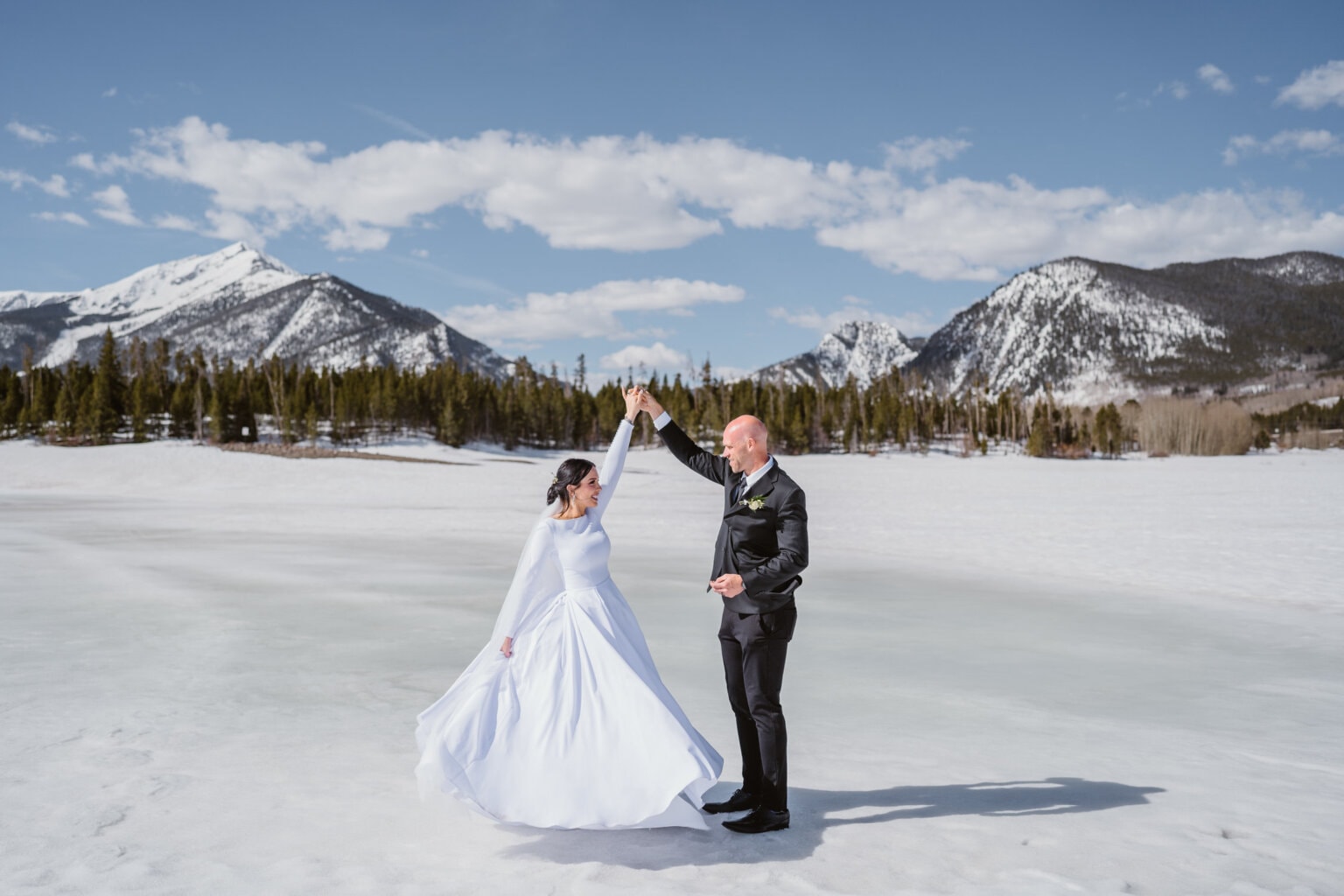 Bride and groom dancing on a frozen lake near Silverthorne, Colorado.