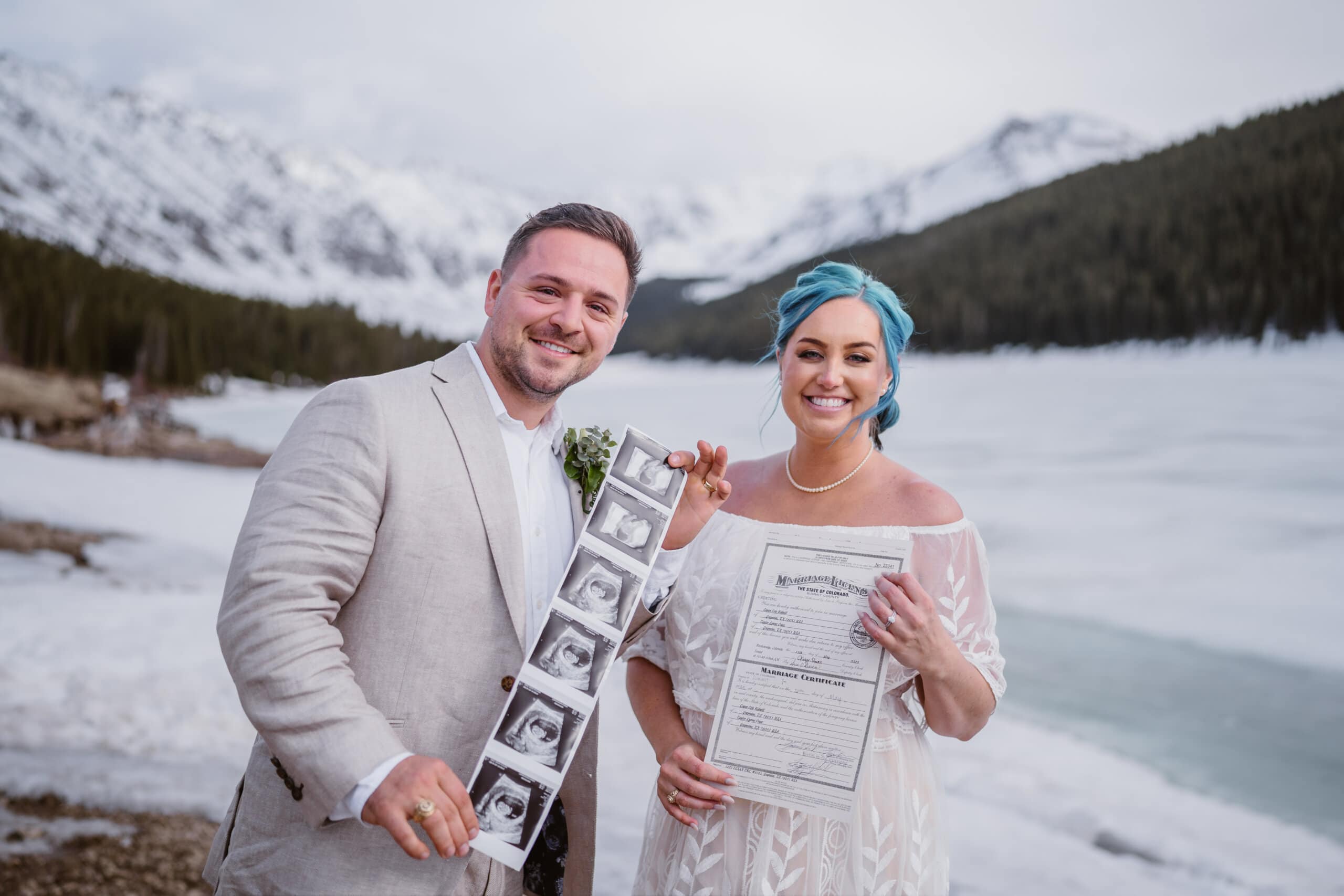 A couple sharing their sonogram and marriage license in Colorado.