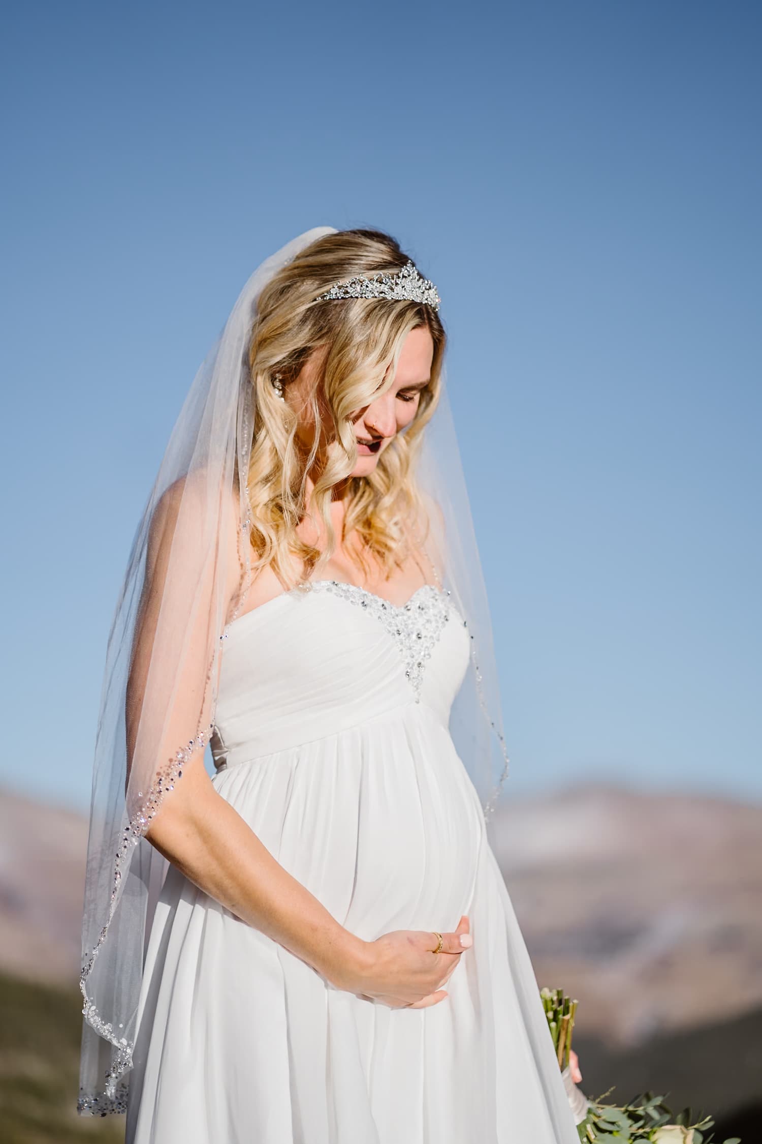 A bride showing off her baby bump on her elopement.