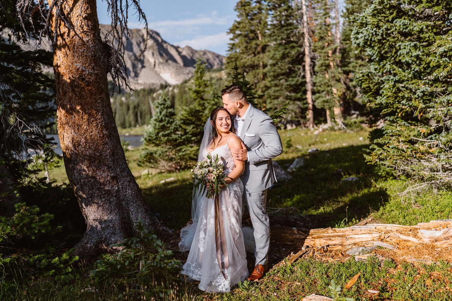 A groom holding his wife in her arms with a kiss on their elopement in Colorado.