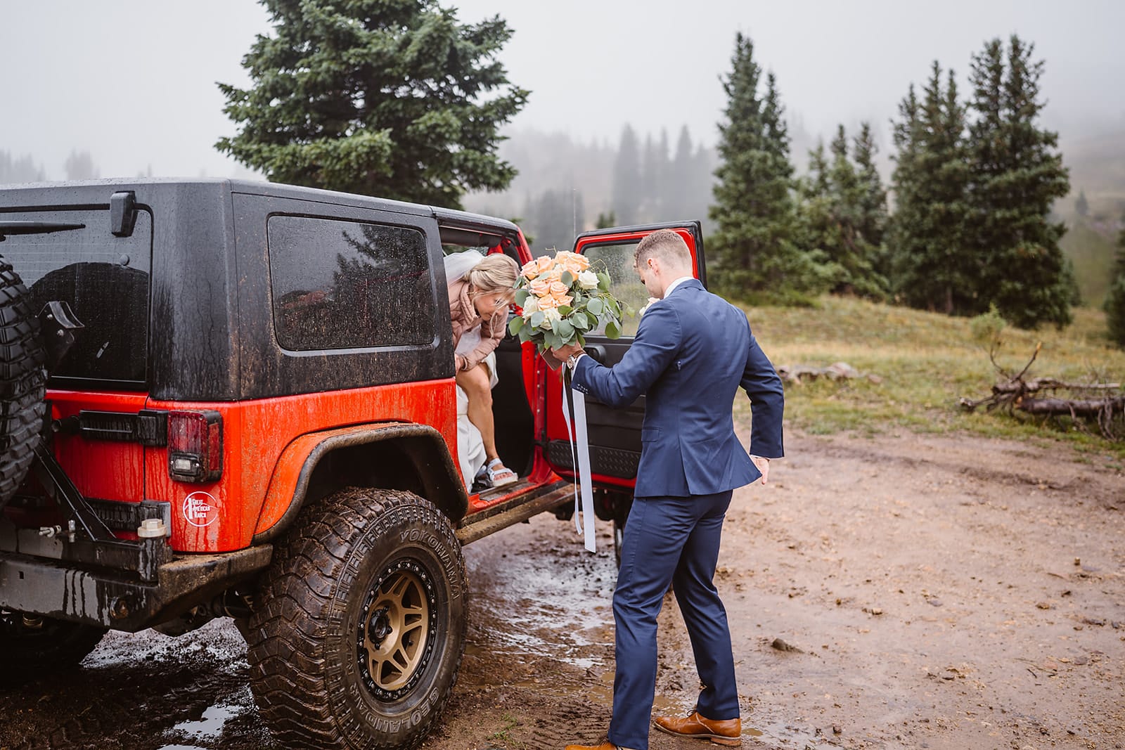 Couple getting out of their jeep at their off roading elopement.