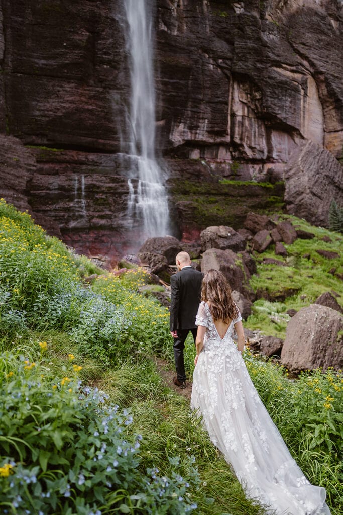 A couple hiking up to a waterfall in Telluride for their elopement. 