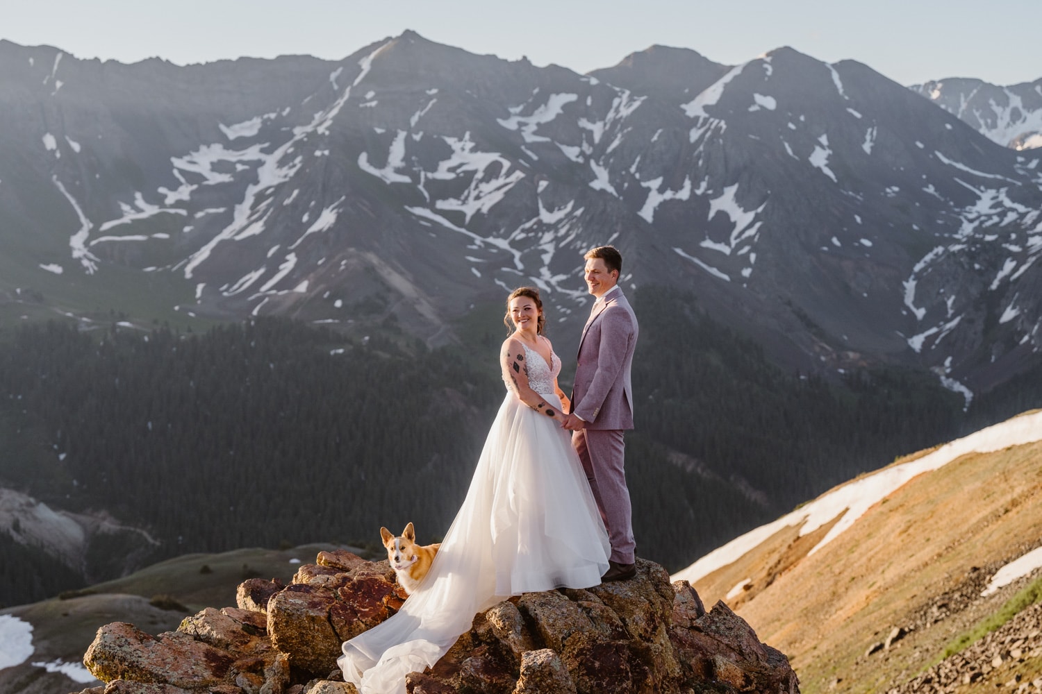 Couple standing in the mountain with their dogs in Colorado.