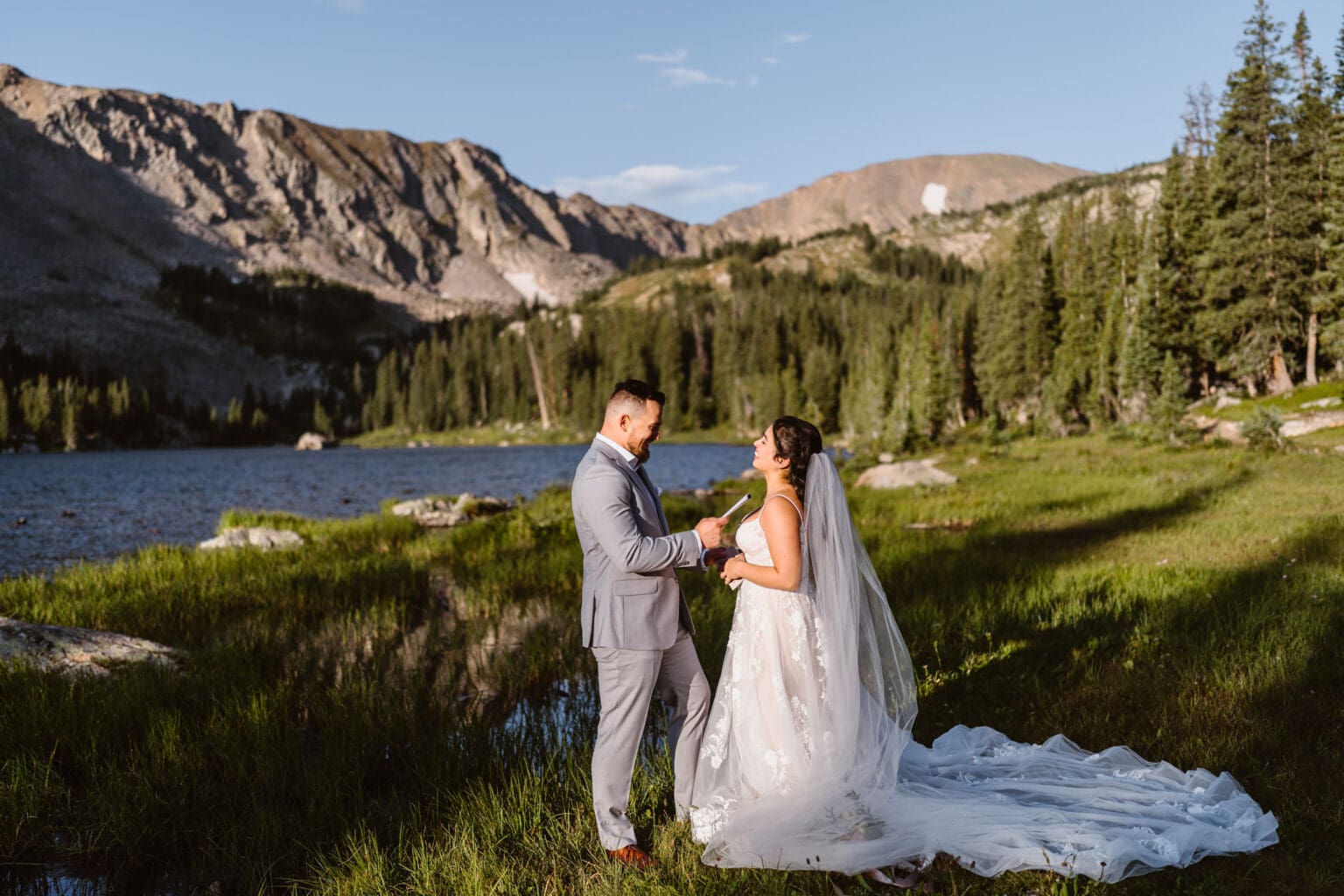Couple sharing their vows at sunrise near an alpine lake during their Self-Solemnization.