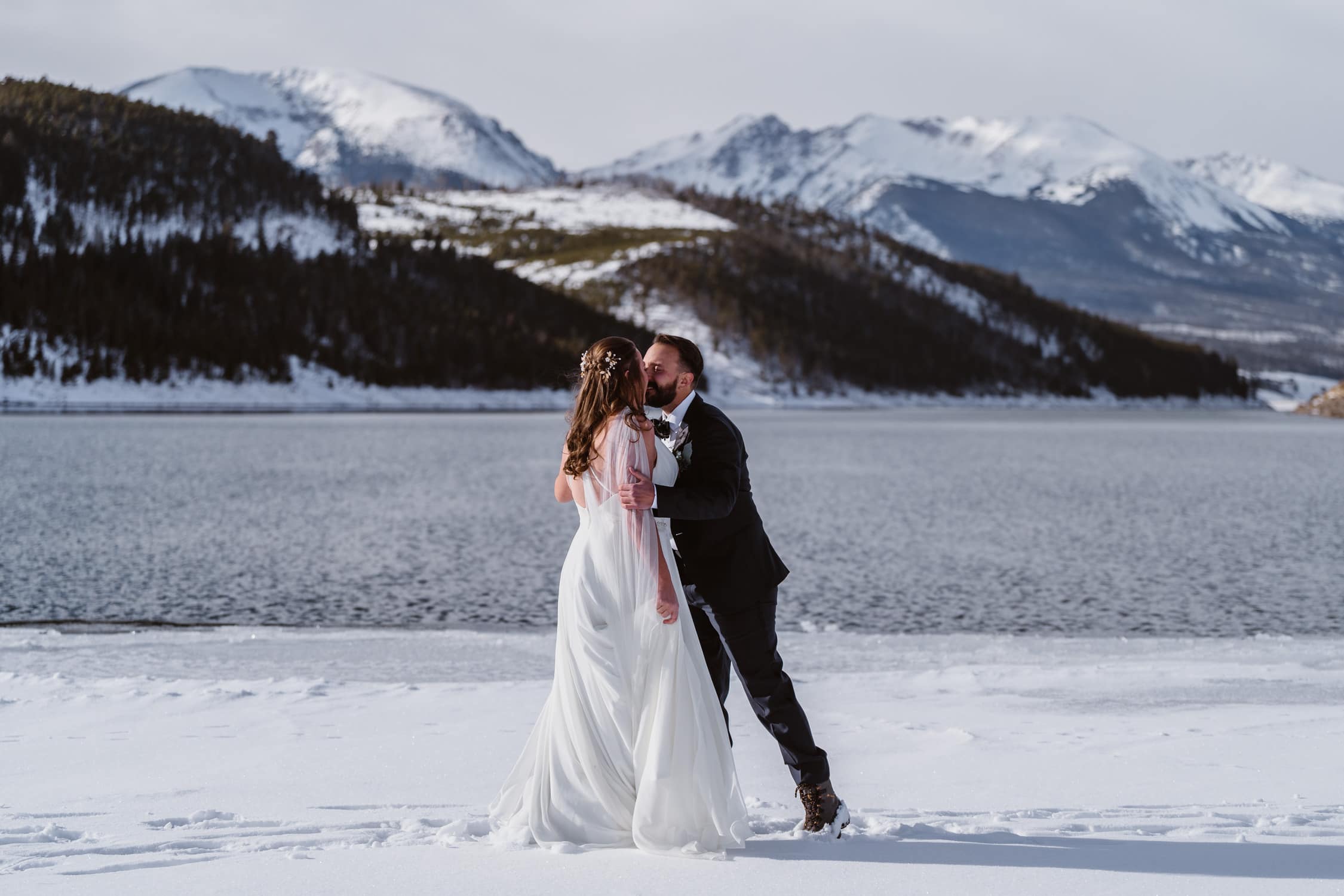 Couple sharing a kiss on the snow during their Colorado elopement.