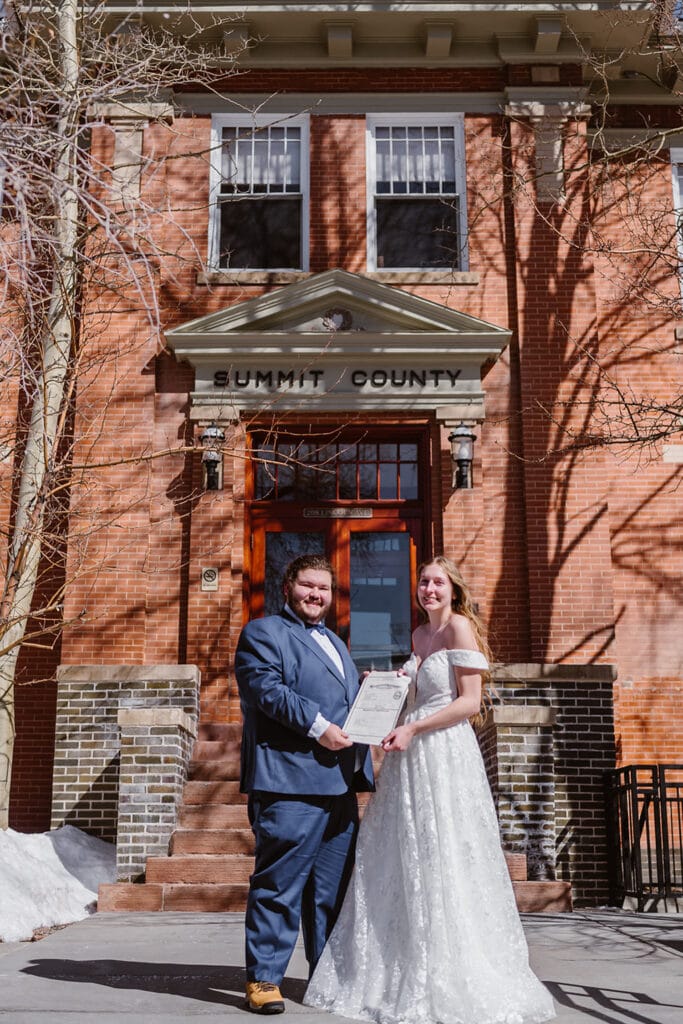 Couple standing in front of Summit County courthouse for their Breckenridge elopement.