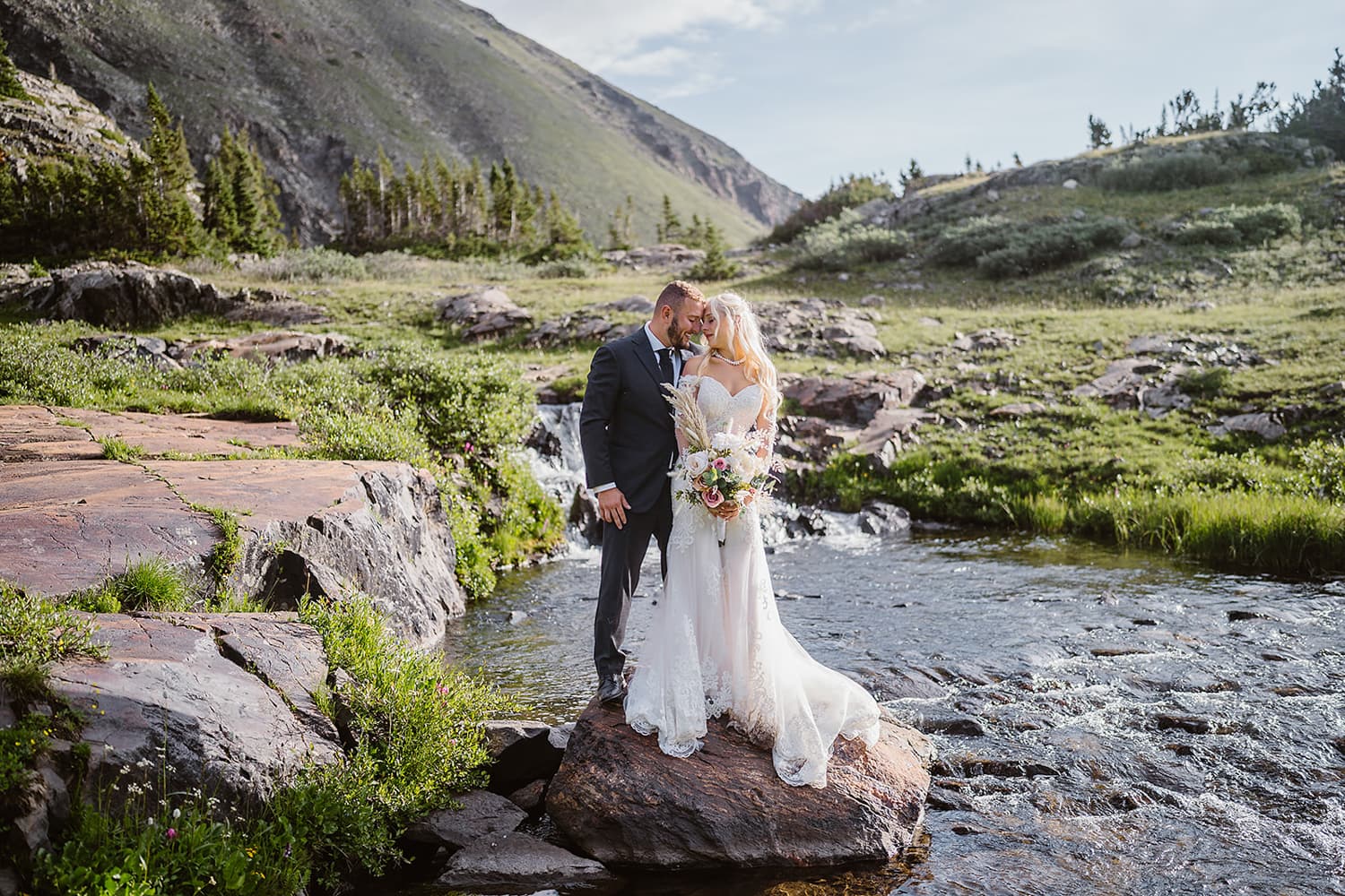 Couple standing on a rock near water for their Breckenridge elopement.