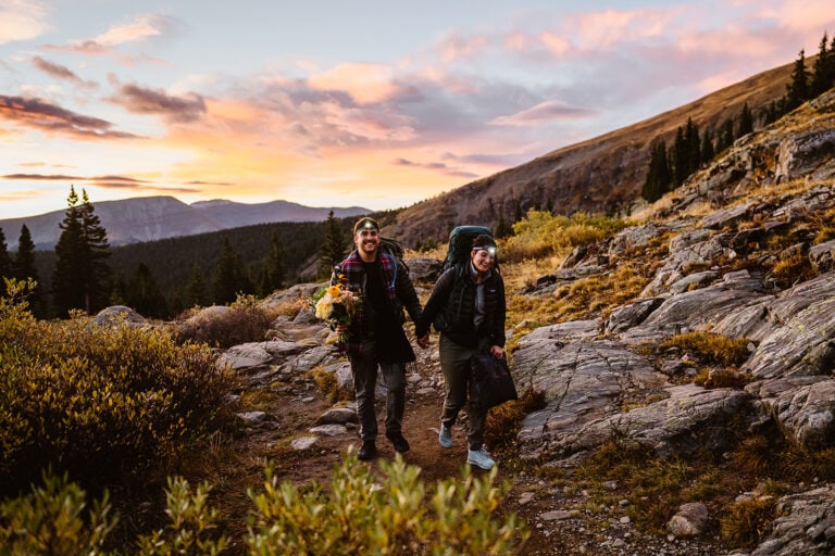 Couple hiking up at sunrise in the mountains for their Colorado elopement.
