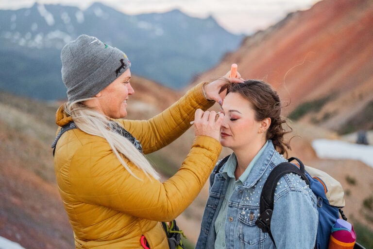 Bride getting her makeup done at sunrise during her Colorado elopement.