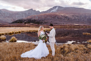 Couples sharing vows solo near a lake in Colorado at fall.