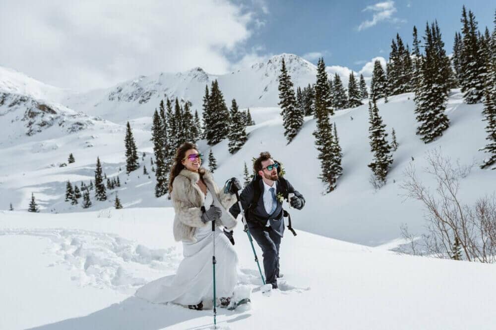 Couple hiking through the snow at their winter elopement in Colorado.
