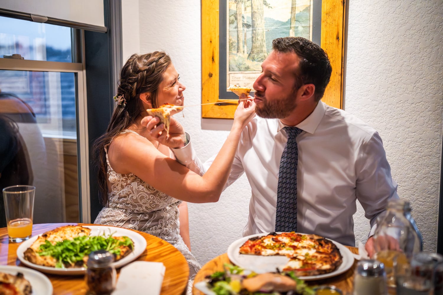 Couple having pizza for their elopement activity.