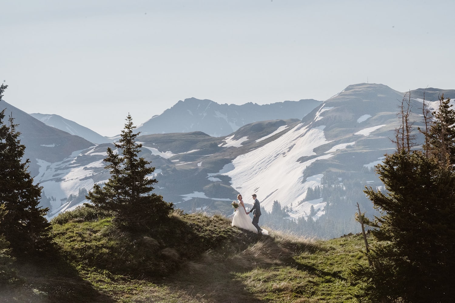 Couple hiking up a mountain at their off roading elopement.