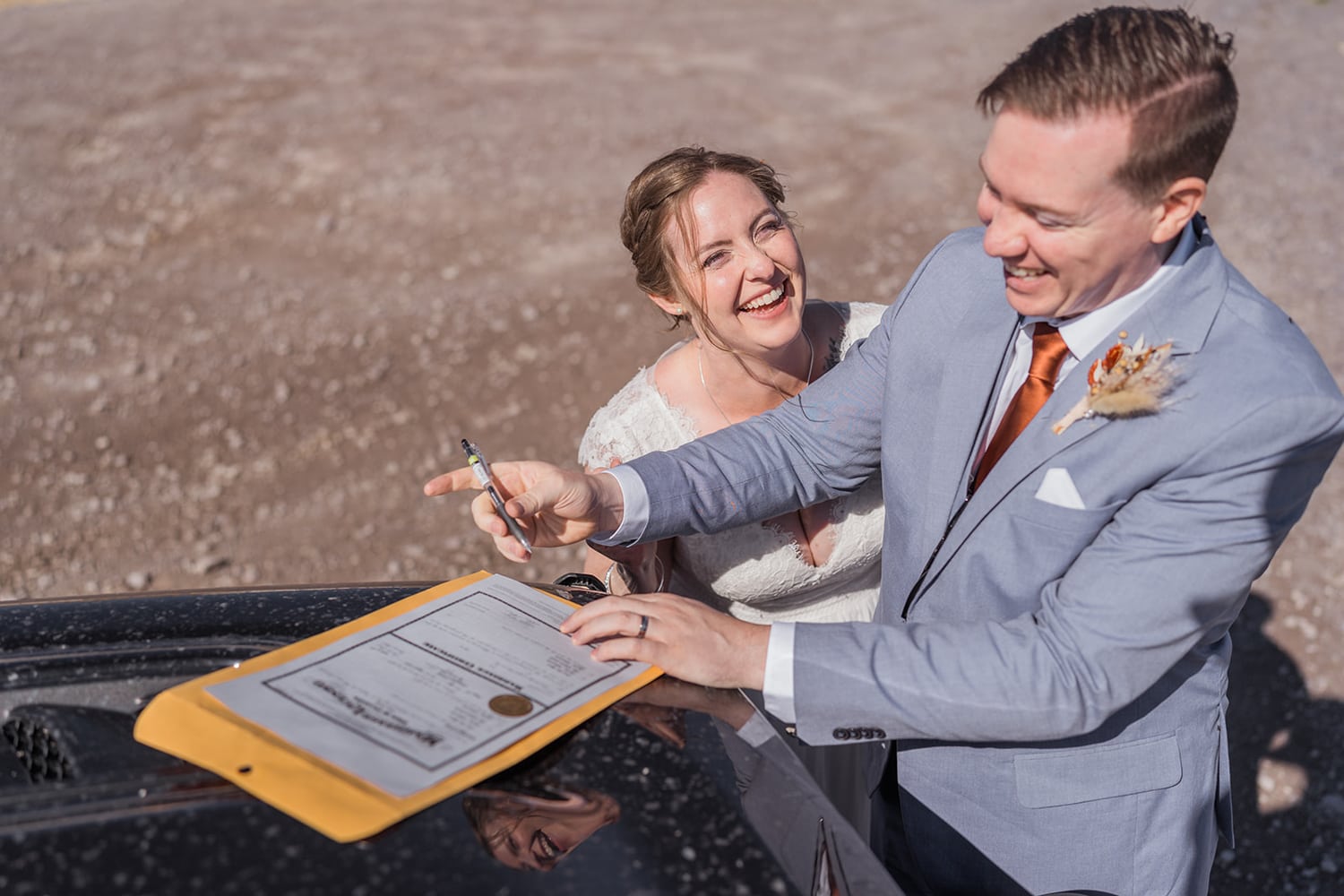 Bride and groom signing their marriage license at their off roading elopement.