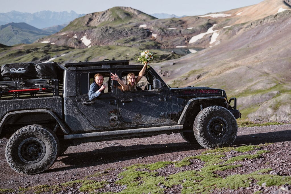 Couple celebrating in a jeep at their off roading elopement.