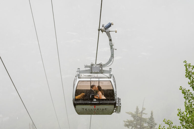 Couple sharing a kiss in a gondola at their Telluride elopement.