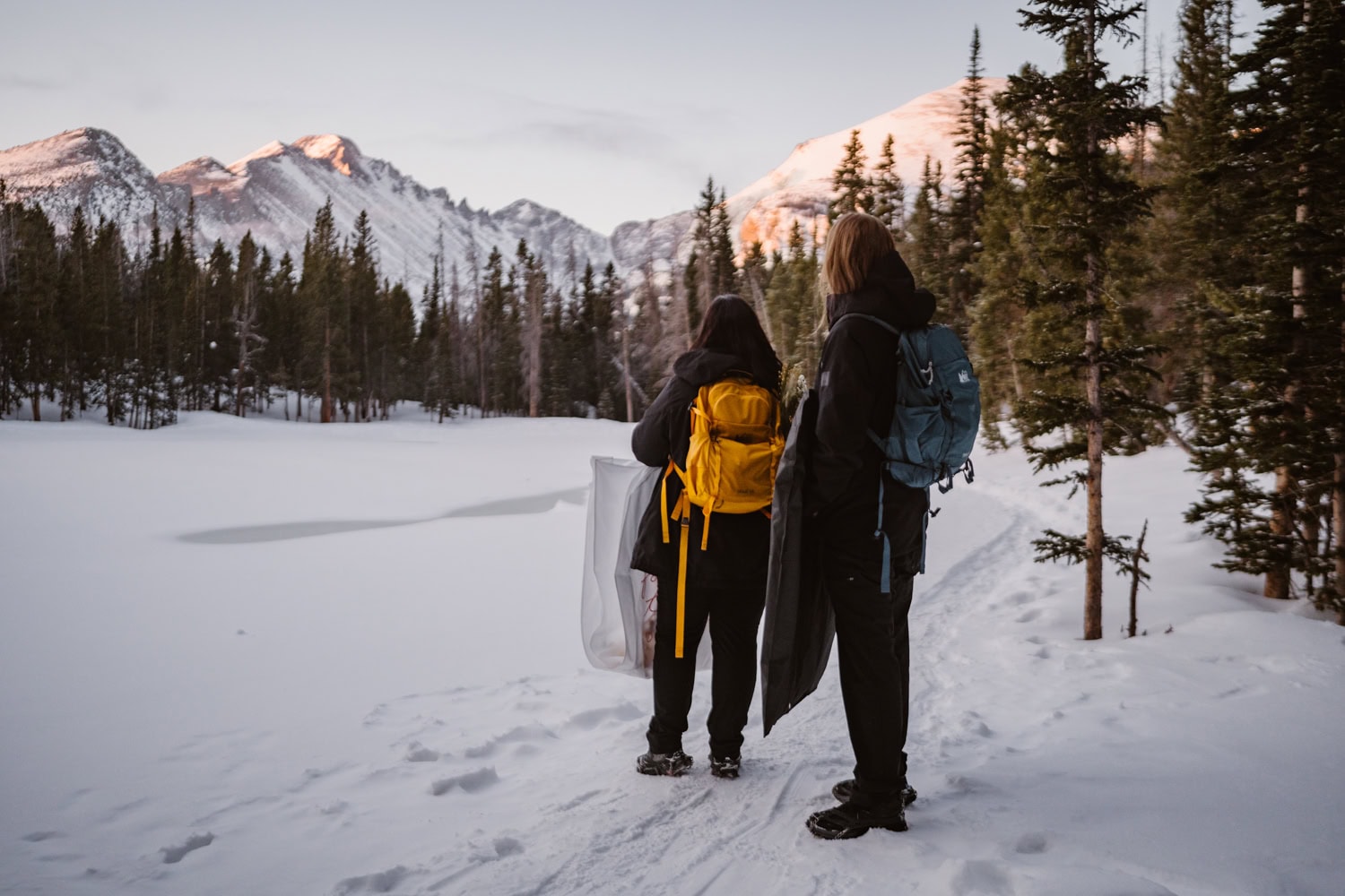 Couple hiking in the snow at their Rocky Mountain National Park elopement.
