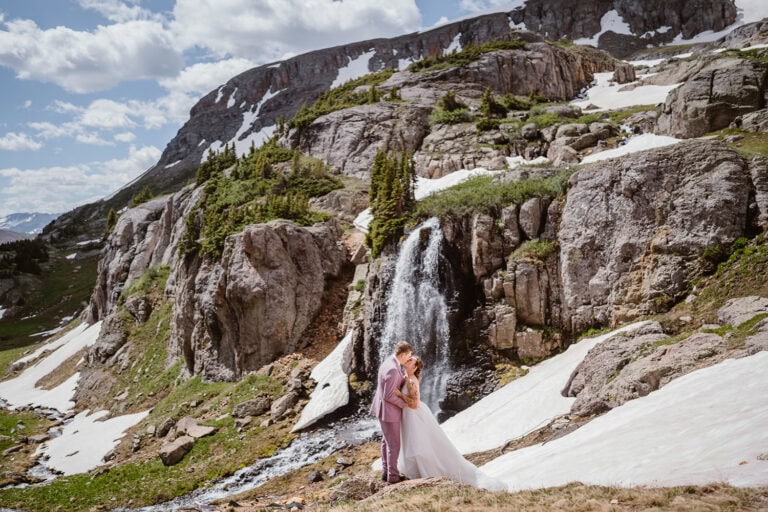 Couple kissing under a waterfall at their Telluride elopement.