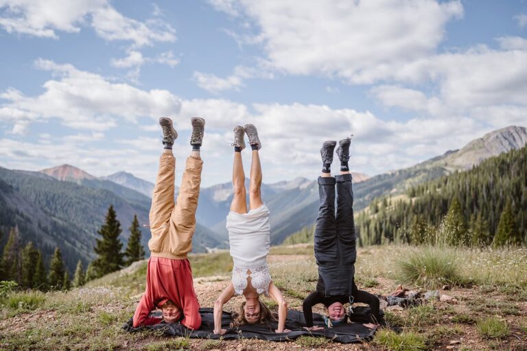 Sean Oblizalo from Vows and Peaks doing a headstand with a couple on their elopement.