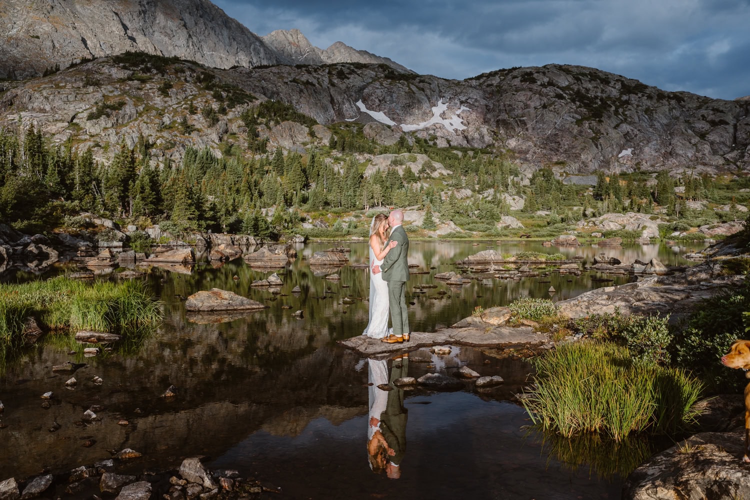 Bride and groom surrounded by the reflections on the water for their Colorado elopement.